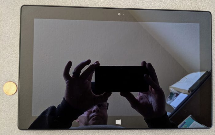 微软Surface RT屏幕的照片与摄影师反射和一个便士的规模